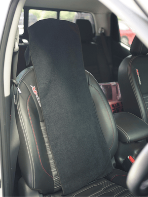 Black gym towel draped over a leather car seat