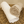 Two rolled towels, one white and one beige, on a wicker basket.
