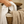 Person holding white towels next to a wicker laundry basket with brown towel.