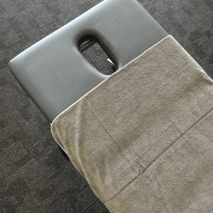 A charcoal massage towel on a massage bed 