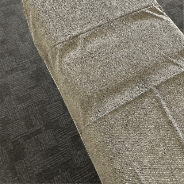 A microfibre massage towel layed across a massage bed 