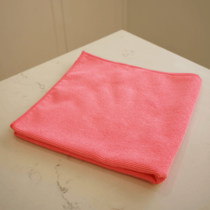 A pink pearl knit microfibre cloth laid on a marble bench